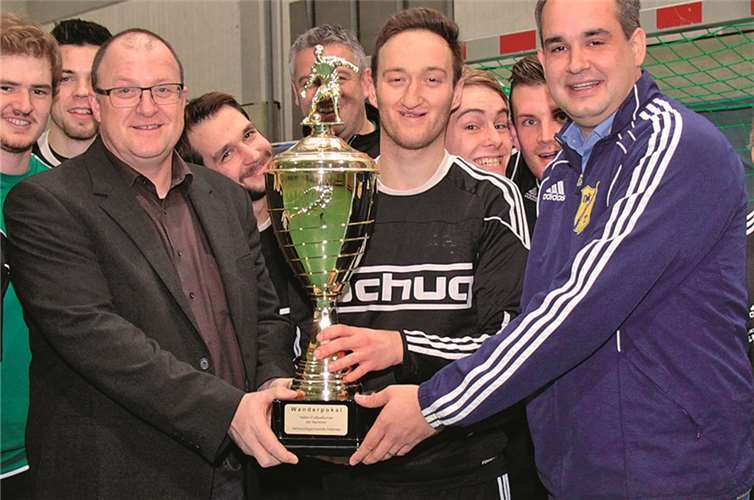 Der Spielführer der SG Hocheifel I Tobias Weiler (Mitte) nahm aus der Hand von VBG Bürgermeister Guido Nisius (Li) und DJK Vorsitzender Mike Mönig (Re) den Pokal entgegen.