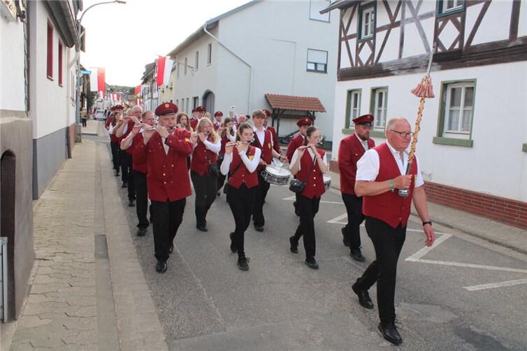 Der Spielmannszug zieht durch den festlich beflaggten Ort.