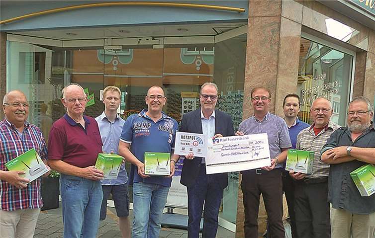 Der Stadtverbandsvorsitzende der UWG Rheinbach, Jörg Meyer, übergibt Augenoptikermeister Michael Firmenich den Scheck über 200 Euro.privat