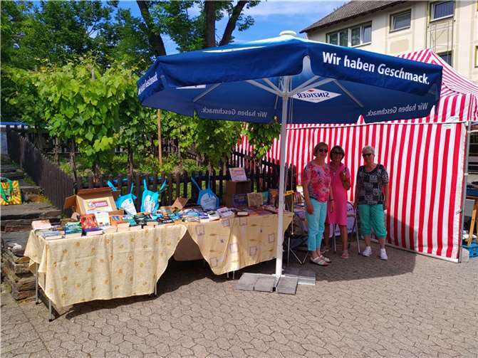Der Stand auf dem Bad Bodendorfer Wochenmarkt und drei Büchereiteam-Mitglieder.  Foto: Stefani Jürries