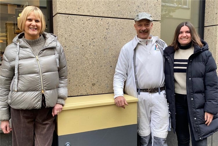 Der Stromkasten fügt sich farblich in die Fassade ein (v.l.n.r.: Susanne Fassbender, Christian Funk, Julia Judt). Fotos: Kerstin Stüwe/Stadt Mayen