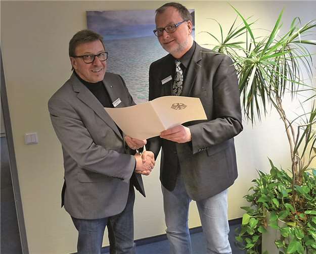 Der Vorsitzende der Geschäftsführung, Karl-Ernst Starfeld, überreicht Ralf Giel die Urkunde zum Dienstjubiläum.  privat