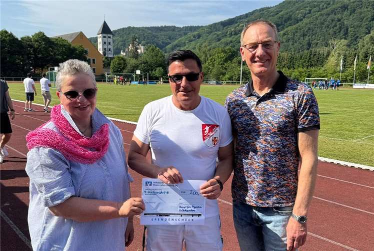 Der Vorsitzende des FSV RW Lahnstein Ingo Karst nimmt den Scheck des BMI – überreicht von Jutta Niel und Günter Groß - im Rhein-Lahn-Stadion in Lahnstein gerne entgegen.  Foto: Sarah Jaeger