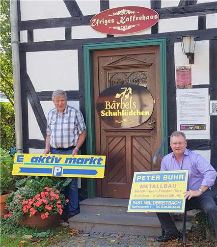 Der Vorsitzende des Gewerbeverbands, Klaus Peter Paffhausen (links), und Viktor Schicker vom Förderkreis präsentieren alte Firmenschilder. privat