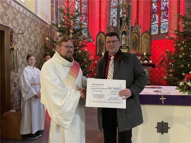 Der Vorsitzende des Schiefervereins, Andreas Klotz, überrascht den Diakon Michael Przesang (von rechts) mit einem Spendenscheck im Weihnachtsgottesdienst in Müllenbach. Foto: Dirk Lescher