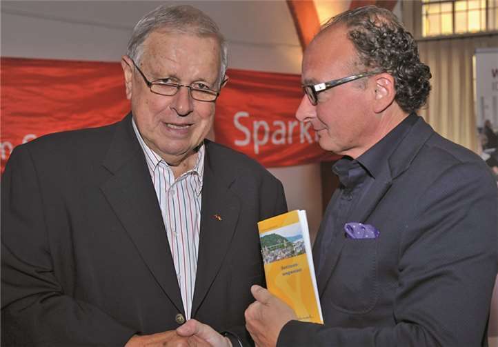 Der Vorsitzende des Seniorenbeirats, Roland Walther, übergibt den ersten neuen Seniorenwegweiser an Oberbürgermeister Achim Hütten (r.).Stadt Andernach/Maurer