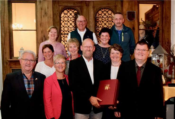 Der Vorstand verabschiedet den langjährigen Jugendleiter Olaf Witthaus (Mitte mit Weinpräsent).Foto: -KG-