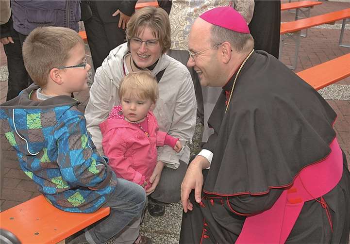 Der Weihbischof beim Rundgang auf dem Kirchplatz nach dem Gottesdienst, freundliche Gespräche mit allen Generationen.