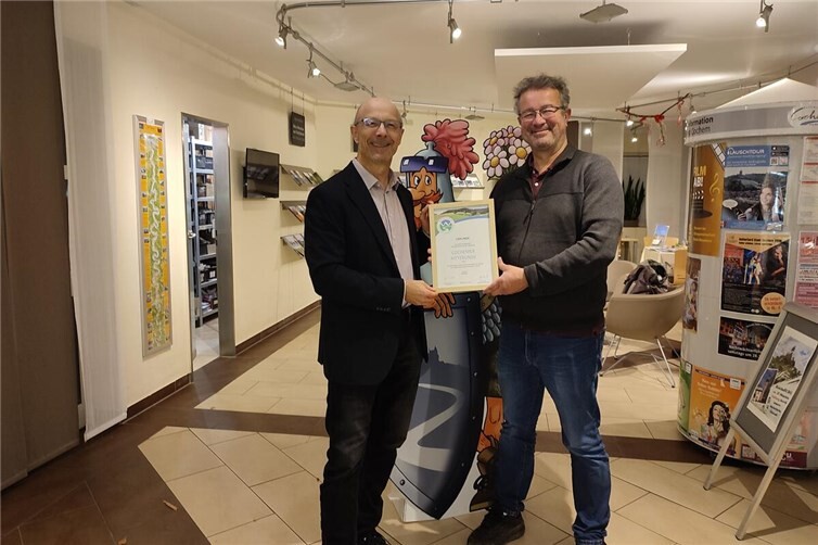 Cochemer Ritterrunde: Premiumwanderweg erreicht Spitzenbewertung  Der Zertifizierer Manuel Andrack vom Deutschen Wanderinstitut übergab Ende Oktober 2025 dem Leiter der Tourist-Information Ferienland Cochem, Harald Bacher, die Urkunde mit dem Wandersiegel für die Rezertifizierung. Foto: Tourist-Information Ferienland Cochem