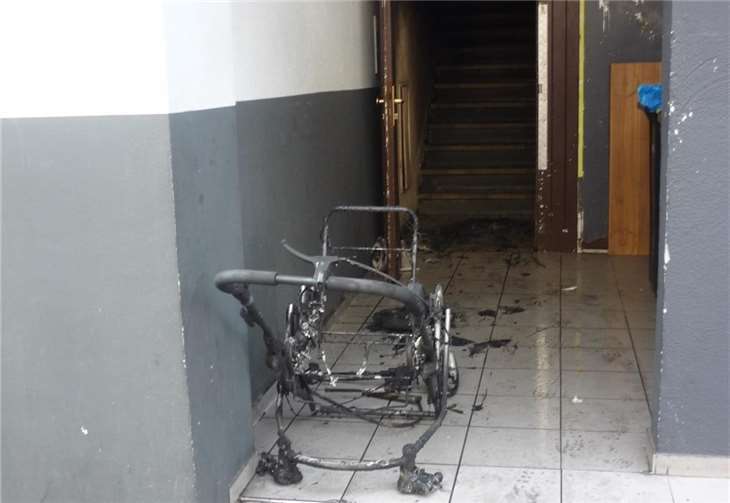 Der abgebrannte Kinderwagen in dem Hausflur des Mehrfamilienhauses in Koblenz. Polizei
