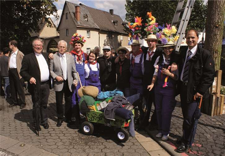 Der diesjährige Schießjahrgang gemeinsam mit Pfarrer Thomas Gerber (links), dem Vorsitzenden der Kirmesgesellschaft Reinhold Milde (2. von links) und dem St. Sebastianer Ortsbürgermeister Marco Seidl (rechts).