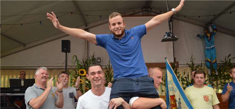 Der frisch gebackene Hahnekönig Tom Robin Gabler auf den Schultern seiner Junggesellenkameraden. AB