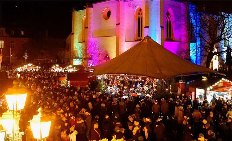 Der gut besuchte Mitternachts-Weihnachtsmarkt vor der prächtig illuminierten Kirche St. Laurentius.KG