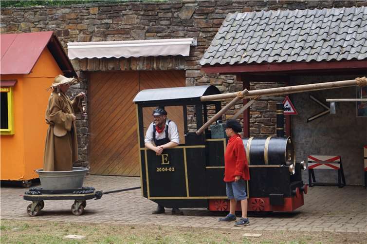 Der kecke Jim Knopf (rechts) und sein väterlicher Freund Lukas, der Lokomotivführer (Mitte) bringen den Scheinriesen nach Lummerland.