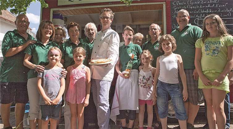 Der knallrote Wagen, indem Philipp Röhrig (Mitte) Original Elsässer Flammenkuchen zubereitete, war eine der Hauptattraktionen beim diesjährigen Sommerfest der KG Grün-Weiß Esch auf dem Dorfplatz. VJ