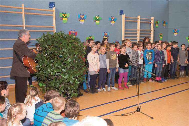 Der musikalische Schulleiter Wolfgang Runkel (links) begleitete mit der Gitarre die Schüler der Klasse 4 bei ihrem Gesangsvortrag.