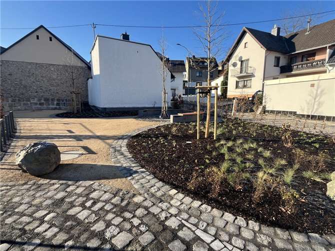 Der neue Dorfplatz in der Bachstraße mit der hinten liegenden Sitztribüne aus Grauwacke-Blöcken.  Foto: Christof Bürger