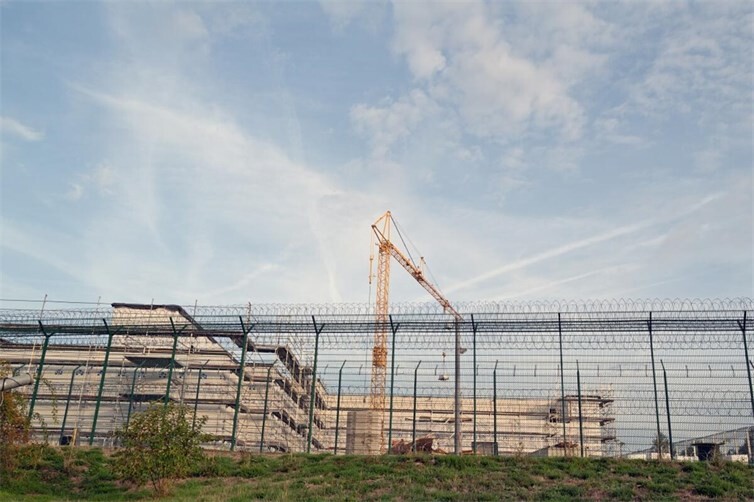 Der neue Erweiterungsbau am Haus M mit dem Sicherheitszaun der Klinik im Vordergrund.