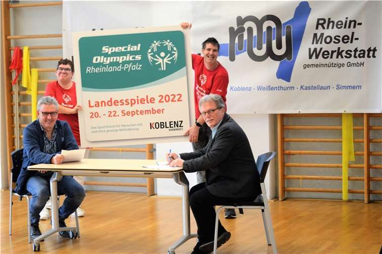 Der neue Geschäftsführer von Special Olympics und der Geschäftsführer der Rhein-Mosel-Werkstatt unterschrieben den Partnerschaftsvertrag. Mit dabei waren in der Sporthalle der RMW Tanja Dötsch und Christian Pischke, die Botschafter der Landesspiele 2022. Foto: TomTom PR Agentur / Special Olympics Rheinland-Pfalz e.V.