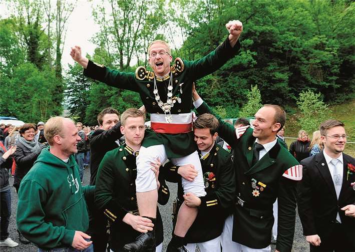 Der neue Schützenkönig Peter Ropertz wird auf den Schultern der Fähnrichsbegleiter den Zuschauern präsentiert.