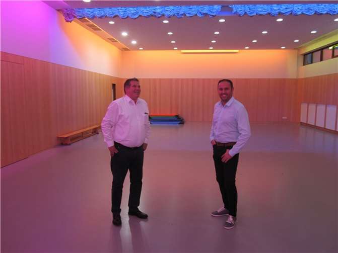 Der stv. Vorsitzende der CDU-Macken, Marco Kneip, stellt VG Bürgermeisterkandidat Jens Firmenich das jüngst im Innern modernisierte Dorfgemeinschaftshaus vor. Vom angegliederten Kindergarten „Regenbogen“ aus kann der Saal des Dorfgemeinschaftsgemeinschaftes ideal als Bewegungsraum für die Kinder genutzt werden.  Foto: Peter Scheidweiler
