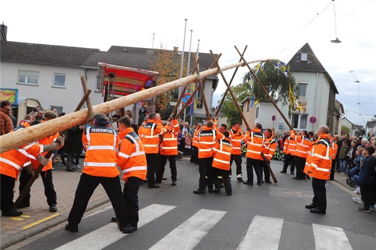 Der über 20 Meter lange Kirmesbaum wurde durch die Feuerwehr zum Kirmesplatz getragen und aufgestellt. Fotos: WAMFO.DE