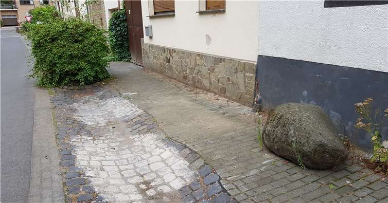 Der zur Durchführung der Baumaßnahme auf dem Bürgersteig abgelegte mehrere Zentner schwere Findling wurde nicht etwa wieder an seinen ursprünglichen Standort zurück versetzt, sondern einfach auf dem Bürgersteig liegen gelassen.Foto: privat