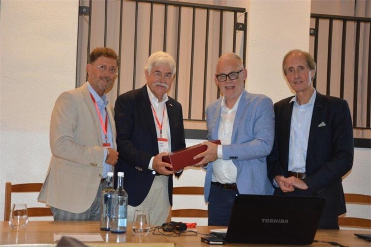 Detlef Odenkirchen, Elmar Lersch, Prof. Dr. Uwe Wagschal und Prof. Dr. Dr. Franz-Josef Schneider stellen sich zum Pressefoto bei der Übergabe des Gastgeschenks