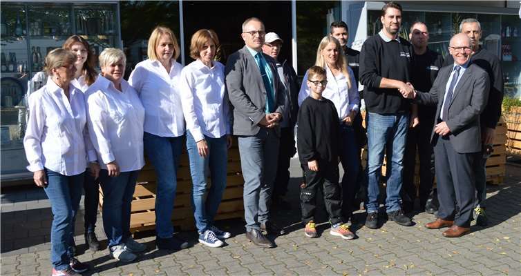 Detlef Placzek gratuliert Michel Juchem zum Landespreis im Beisein der kompletten Belegschaft.