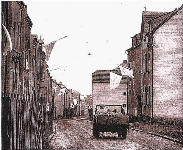 Deutsche Bürger hängen Dutzende von weißen Fahnen aus, als ein amerikanischer Jeep in eine kleine Stadt auf dem Weg nach Koblenz einfährt.Archiv „Bilder aus der Vergangenheit“ von Winfried Henrichs