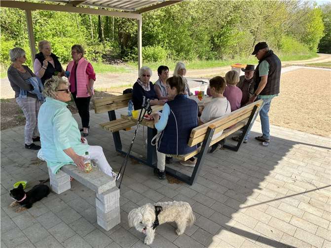 Di Spaziergangsgruppe samt „Begleiter“ rastet an der Sitzgruppe und stärkt sich.  Foto: Olaf Wulf