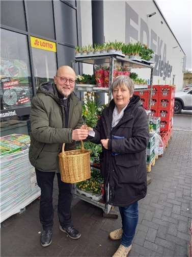 Diakon Norbert Schmitz (li.) überraschte die Dame vor dem Ostereinkauf mit einem kleinen Palmstrauß. Foto: Bernd Gilles