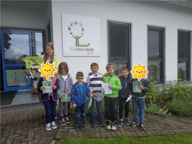 Diana Wallstein, Mitarbeiterin der KiTa „Villa Kunterbunt“ und die Dinobande freuen sich über die Führerscheine, mit denen sie die Bücherei erkunden können!Foto: privat