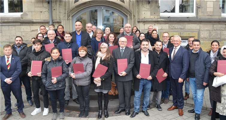 Die 34 Neubürger freuen sich mit Achim Hallerbach (5. v. re.) über ihre Einbürgerungsurkunden.Foto: Kreisverwaltung