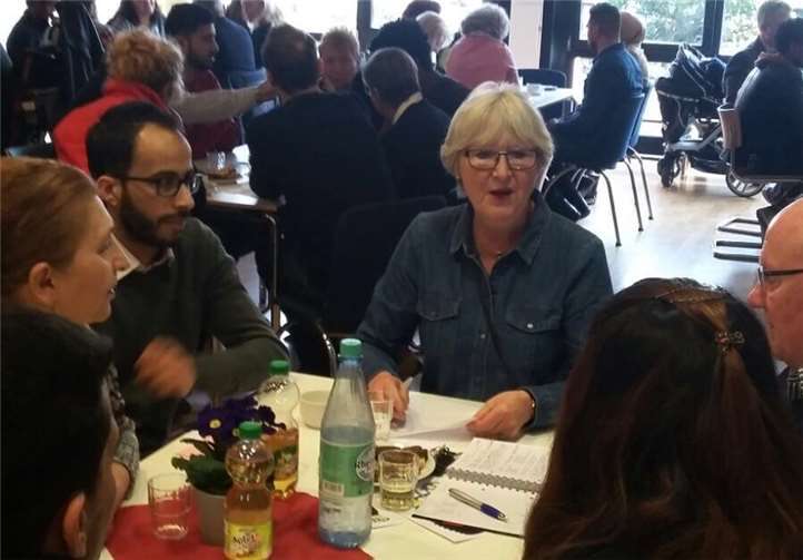 Die AG-Vorsitzende Heidi Wiens unterhält sich angeregt an einem der Tische des Dialoges. Stadt Meckenheim