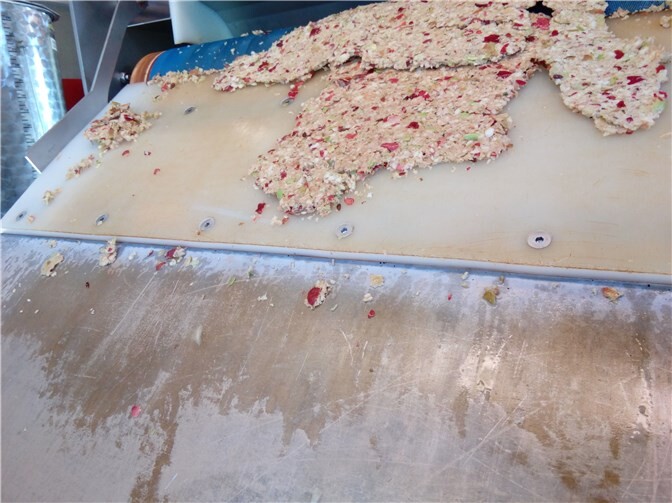 Die Äpfel werden durch eine Apfelpresse geführt.