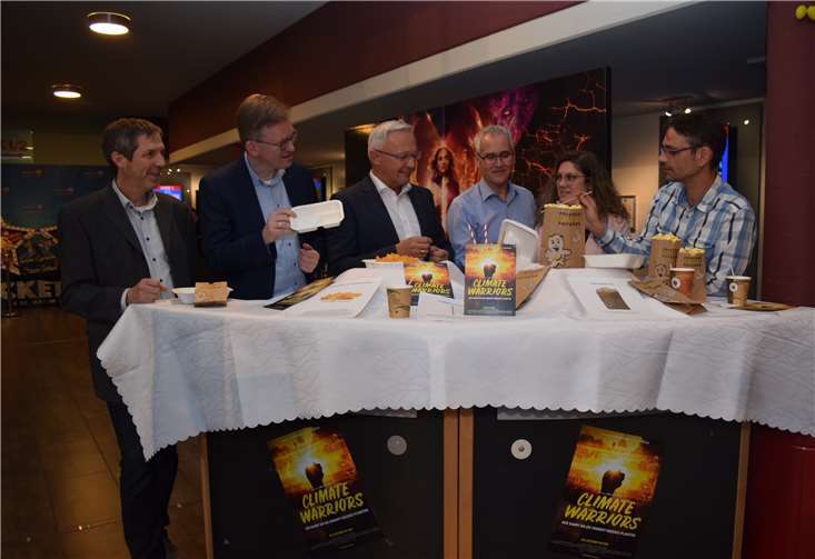 Die Akteure des Abends Martin Knopp, Energieberater der Verbraucherzentrale Rheinland-Pfalz,Moderator Marcelo Peerenboom, Landrat Achim Hallerbach, Udo Engel, Stadtwerke Neuwied, undOrganisatorin Gabi Schäfer von der Kreisverwaltung Neuwied informieren sich beimKinoleiter Thomas Bilgenroth über die Plastikmüllvermeidung durch den Einsatz vonalternativen Papier- und Zuckerrohrprodukten im Cine 5.
