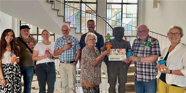 Mayen setzt auf Fairness beim Handel  Die Anwesenden der Steuerungsgruppe setzen mit der Aktion „Kleine Puppen – große Botschaft“ ein Zeichen für Vielfalt.  Foto: Zoe Mertz/ Stadt Mayen