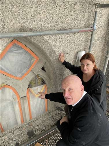 Die Architektin Tina Merfeld (hinten) zeigt Pfarrer Michael Wilhelm (vorne), dass die Naturwerksteine der Fenster in Teilen deutlich gravierendere Schädigungen aufweisen als angenommen.  Foto: Dirk Lescher
