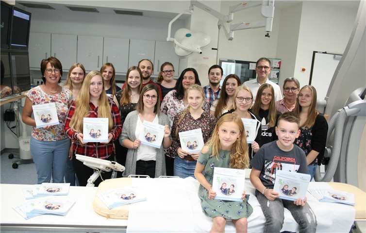 Die Auszubildenden des Kurse 2016 der MTRA-Schule des Rheinischen Bildungszentrums, die Lehr-MTRAs Stefanie Gebauer (links) und Elisabeth Becker-Kalapis (2. von rechts) und Privatdozent Dr. Götz Lutterbey (hinten rechts), dem Chefarzt des Institutes für Diagnostische und Interventionelle Radiologie und ärztlichen Leiter der MTRA-Schule. Amy Sauer und Louis Nikenich (vorne) standen für die Fotos im Heft „Der Blick in deinen Körper“ Modell.Foto: Andrea Schulze