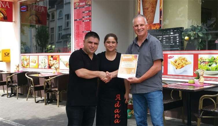 Die Beetpaten bekommen für die Pflege eine offizielle Urkunde der SBN. Auch das Ehepaar Adana, das eine bunte bepflanzte Baumscheibe vor dem Geschäft pflegt, erhielt von Thomas Riehl (re.) eine Urkunde. privat