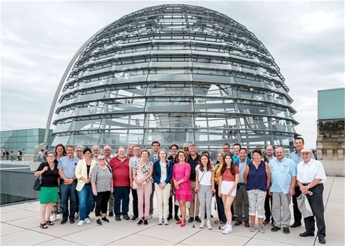 Die Besuchergruppe mit Carina Konrad vor der Kuppel des Reichstages. Foto: Bundesregierung / StadtLandMensch-Fotografie