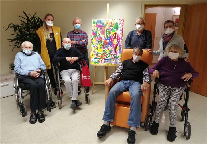 Die Bewohner und Betreuer mit dem zu versteigernden Bild. Foto: privat