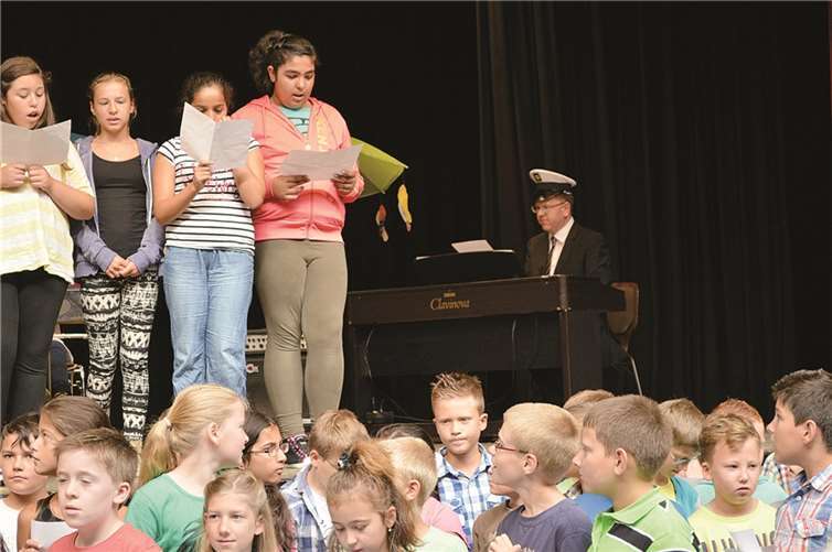 Die Bläserklasse und der Chor mit dem neuen Kapitän Marcus Wald am Klavier. AB