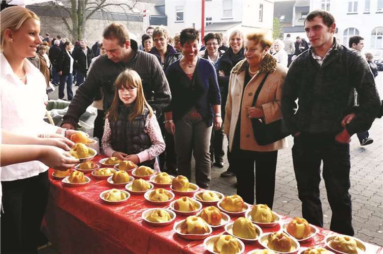 Die Bratäpfel werden vor dem Rewe-Markt in der Bahnstraße werden verteilt.