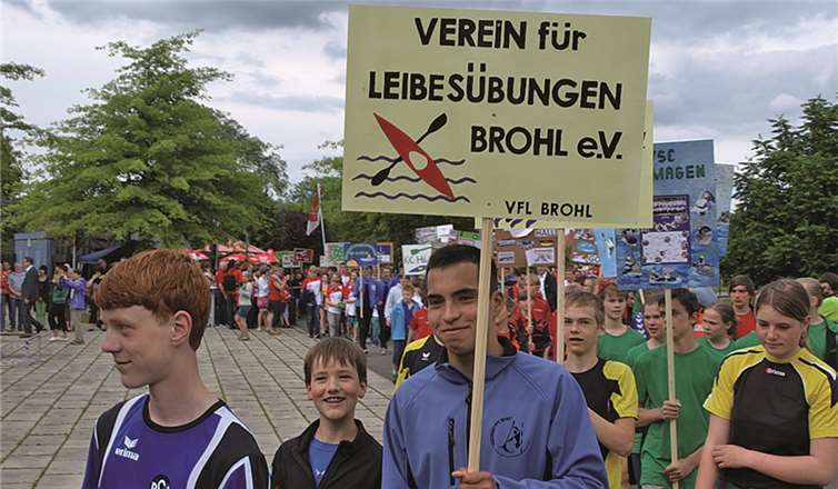 Die Brohler marschieren hinter ihrem Vereinsschild in den Schlosspark zur Eröffnungsfeier. privat