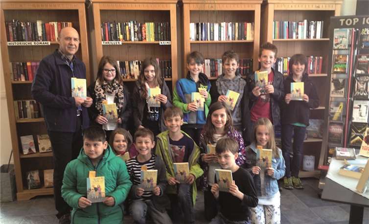 Die „Bücherwürmer“ der Grundschule St.Georg Urmitz haben sich gemeinsam mit Schulleiter Thomas Rauch neuen Lesestoff gesichert.  privat