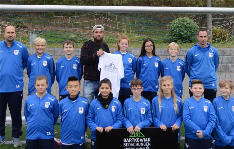 Die D 2-Junioren und ihre Trainer Mike Huber und Dennis Krämer freuen sich riesig über neue Trainingsanzüge und T-Shirts, die ihnen von Dachdeckermeister Robert Bartkowiak gestiftet und vor ihrem letzten Herbstrundeneinsatz in Plaidt überreicht wurden.privat