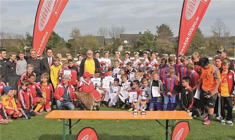 Die D-Junioren des VfL Rheinbach (schwarz-weiße Trikots) und des VfL Meckenheim (blau-rote Trikots) wurden beim Vorrundenturnier des 100pro-Cups in Meckenheim von Markus Feuser, Filialdirektor Vermögensberatung der Kreissparkasse Köln in Meckenheim (hintere Reihe, 5.v.li.) ausgezeichnet. privat