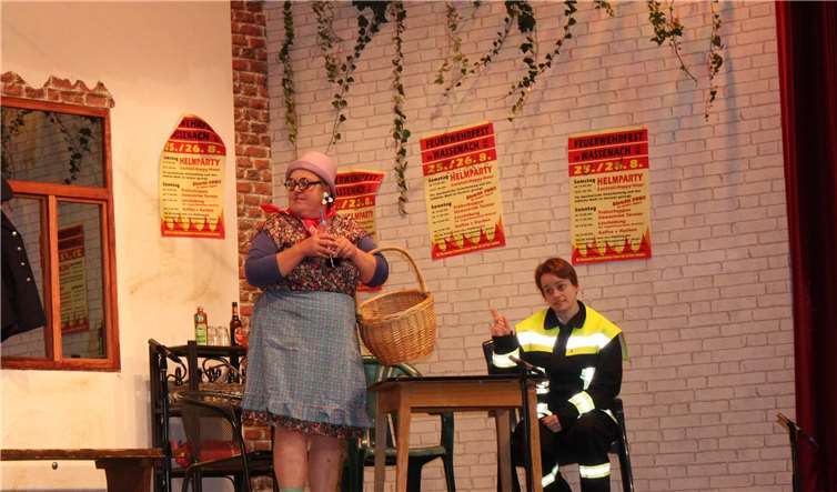 Die Dorftratschliese Grete Knalldall (Melanie Decker) informiert die neue Wehrführerin über die Wehr.